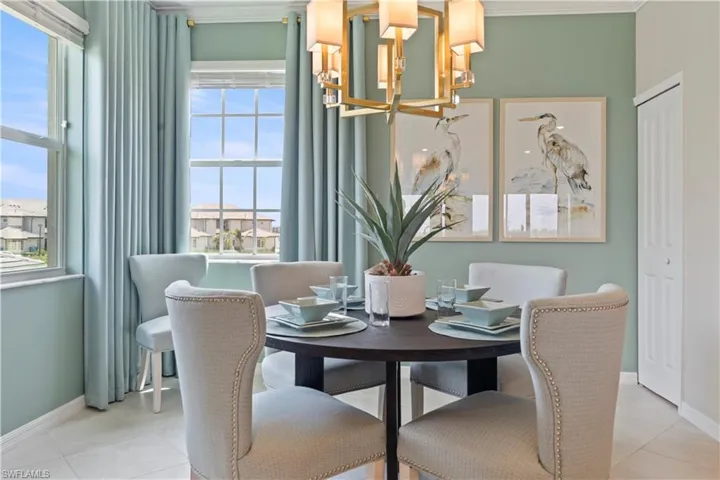 Dining room featuring light tile patterned flooring, a chandelier, and crown molding