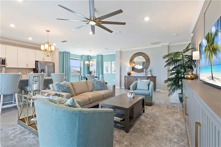 Living room featuring a chandelier, crown molding, ceiling fan, and recessed lighting