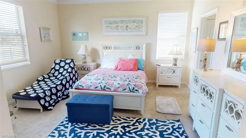 Bedroom featuring light carpet and baseboards