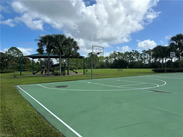 View of basketball court with a lawn and community basketball court