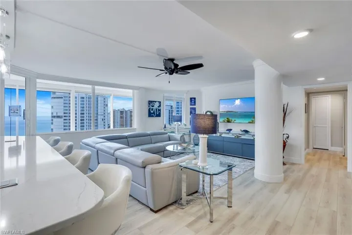 Living area with ceiling fan, baseboards, light wood-style floors, crown molding, and recessed lighting
