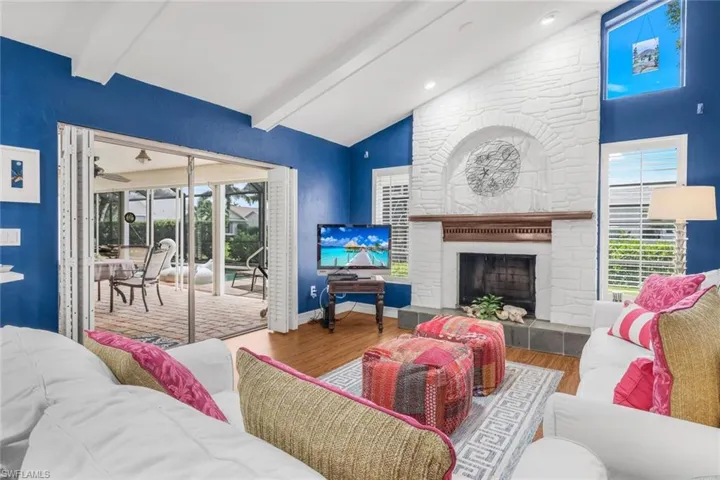 Family room featuring a fireplace, beamed ceiling, high vaulted ceiling