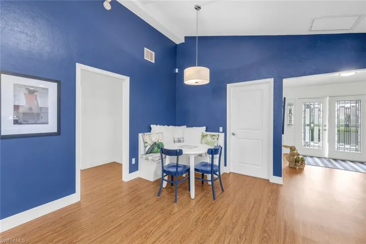 Dining area with vaulted ceiling and hardwood / wood-style flooring