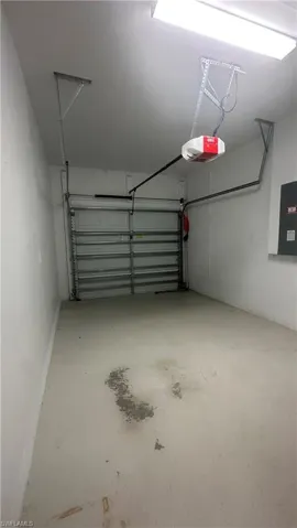 Garage featuring electric panel and a garage door opener