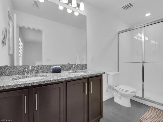 Full bath featuring toilet, a sink, and visible vents