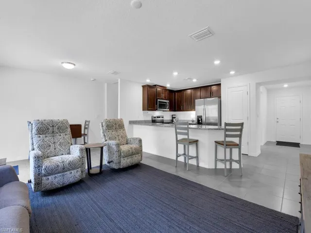 Living area with baseboards, visible vents, recessed lighting, and tile patterned floors
