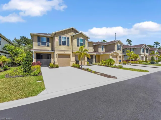 View of front facade with driveway, an attached garage, and a residential view