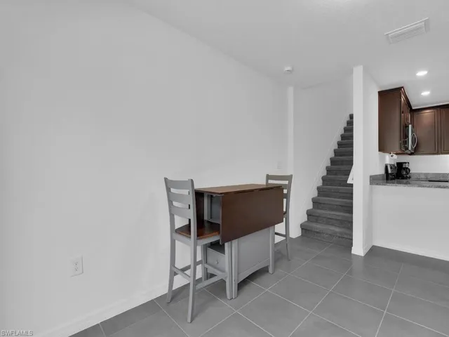 Tiled dining space with stairs, visible vents, recessed lighting, and baseboards