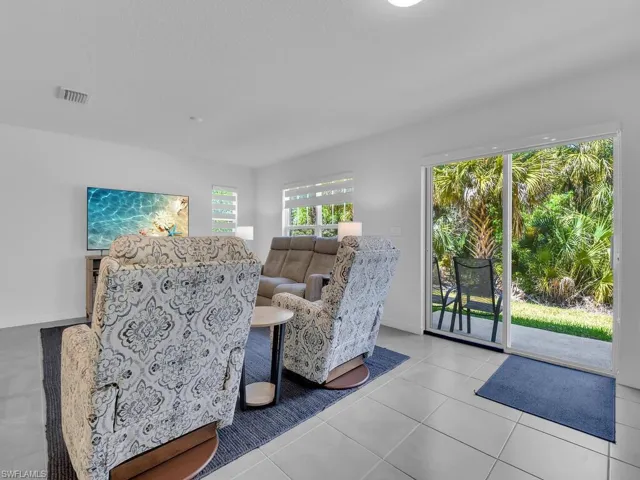 Tiled living room featuring baseboards and visible vents