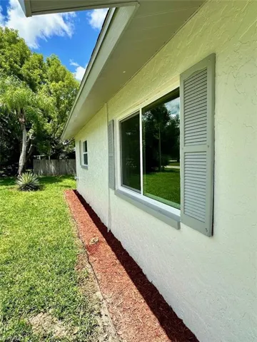 View of side of home featuring a yard
