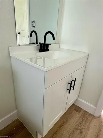 Bathroom featuring large vanity and wood-type flooring