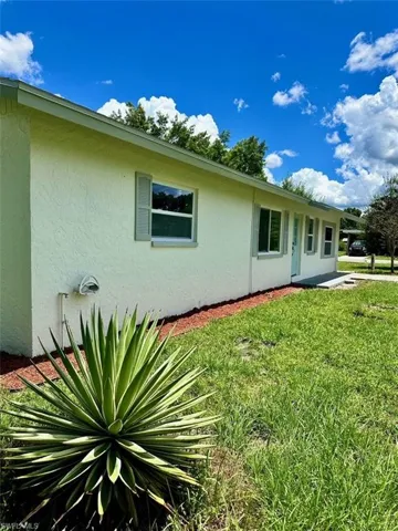 View of side of home featuring a lawn