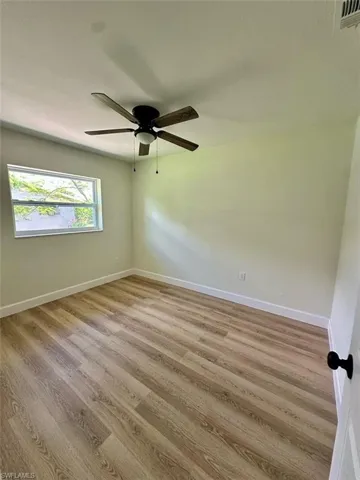 Spare room featuring wood-type flooring and ceiling fan