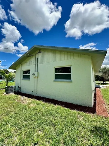 View of home's exterior with a yard and central AC unit