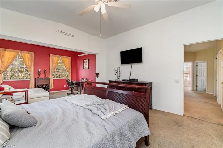 Carpeted bedroom featuring ceiling fan