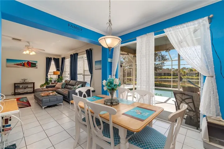 Dining area with crown molding, light tile patterned floors, and ceiling fan
