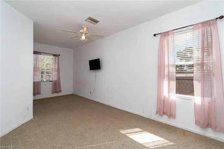 Carpeted spare room featuring ceiling fan
