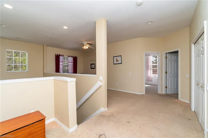 Hallway featuring light carpet
