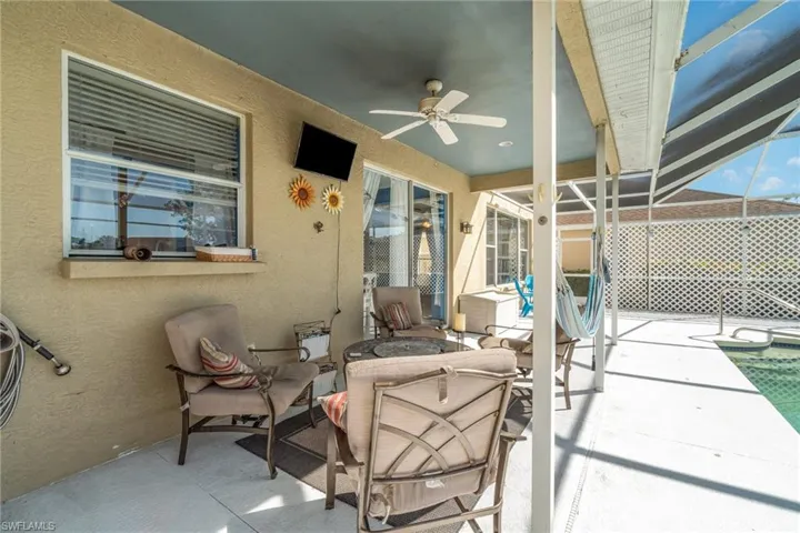 View of patio featuring ceiling fan and a lanai