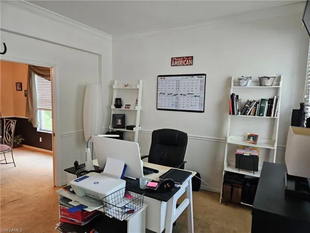 Office space featuring crown molding and light colored carpet