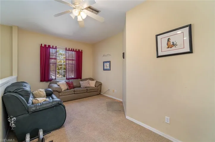 Carpeted living room featuring ceiling fan