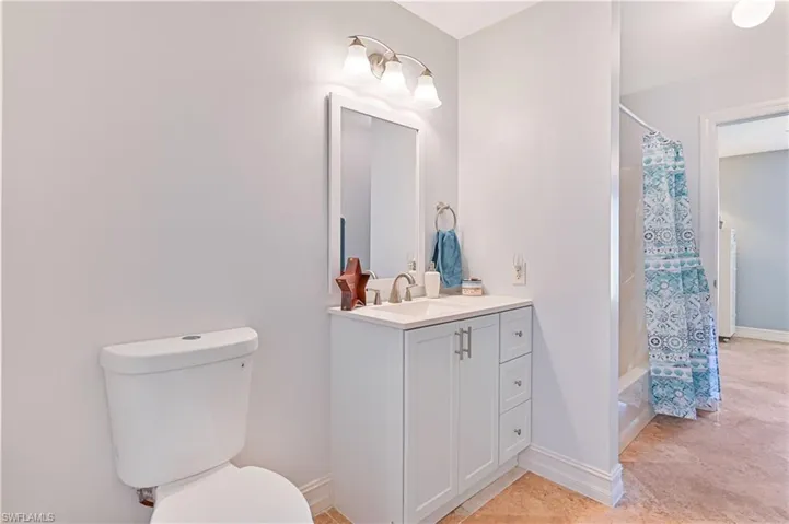 Full bathroom with vanity, light tile patterned floors, and shower / bathtub combination with curtain