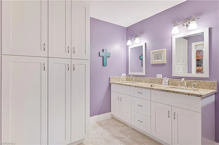 Full bathroom with double vanity and a closet