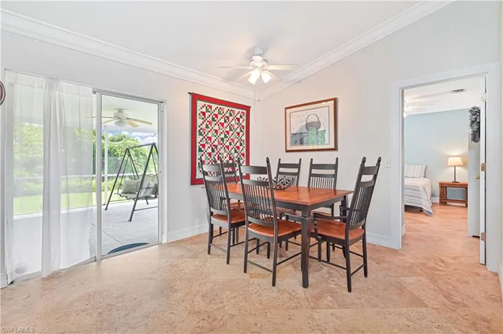 Dining area with ornamental molding and a ceiling fan