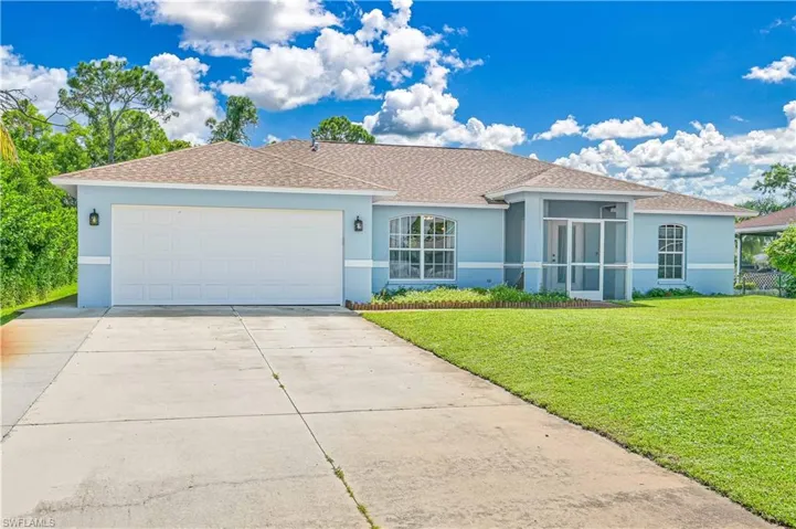 Ranch-style house featuring stucco siding, a shingled roof, a front yard, concrete driveway, and an attached garage