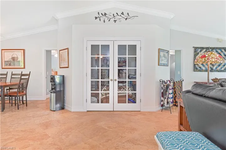 Entryway with crown molding, vaulted ceiling, and french doors