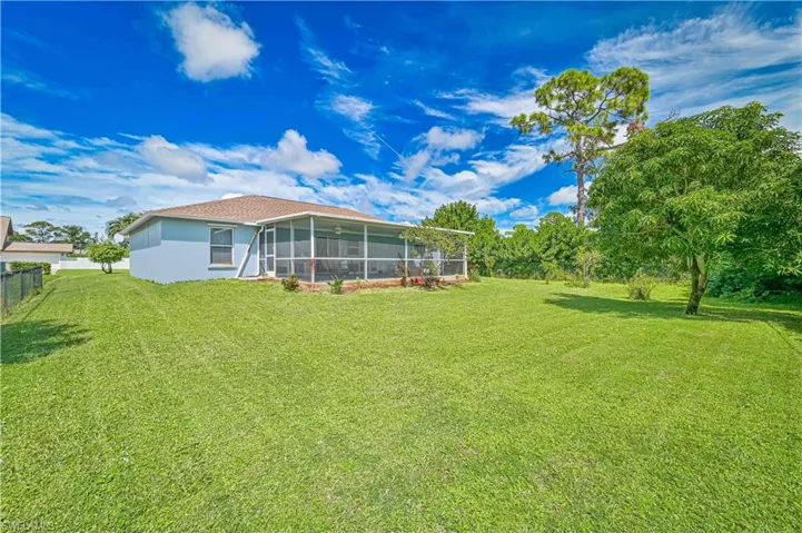 Back of house featuring a sunroom and a yard