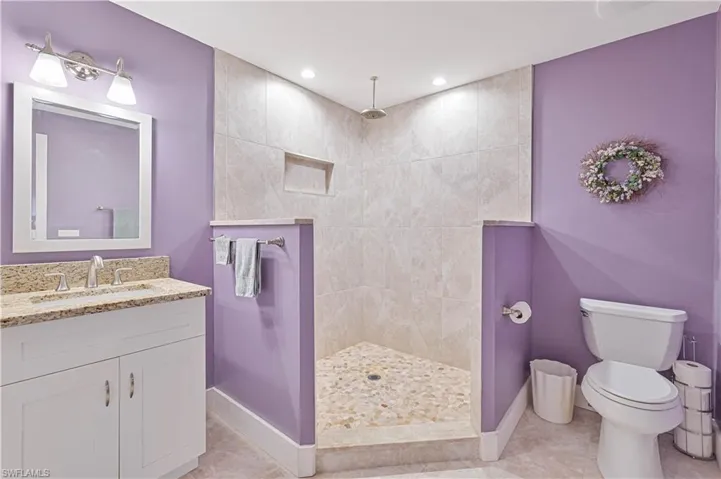 Full bathroom featuring vanity, walk in shower, light tile patterned floors, and recessed lighting