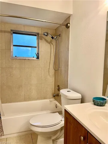 Full bathroom with tile patterned flooring, vanity, toilet, and shower / bathtub combination with curtain