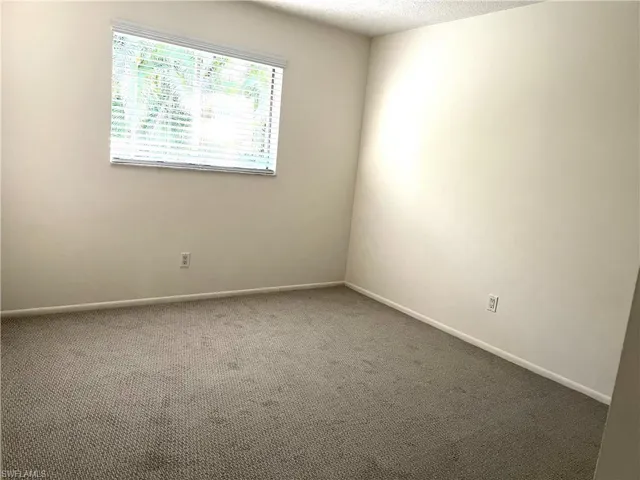 Carpeted empty room with a textured ceiling