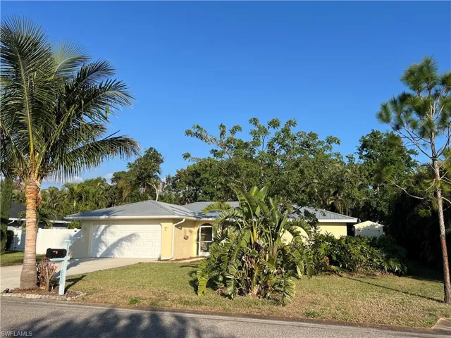 Single story home with a garage and a front yard