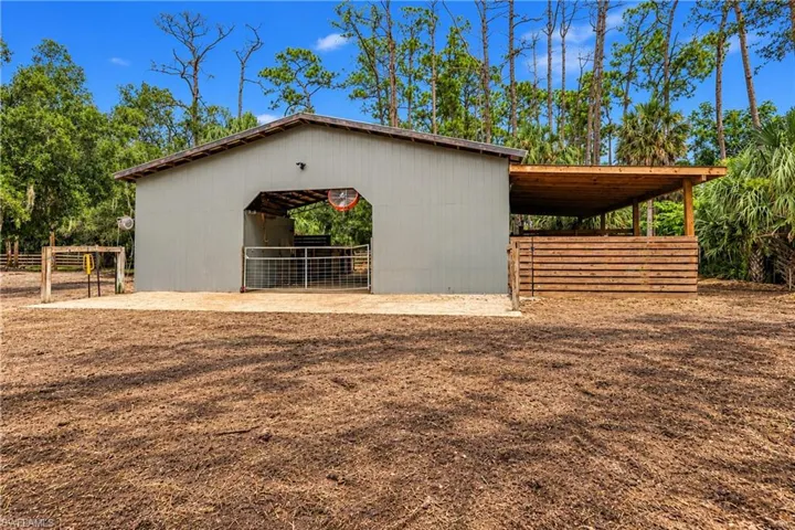 Pole barn structure with a metal roof and an open-sided covered area has 8 stalls and a foaling stall as well. Power, water, fans, and an air-conditioned tack room.