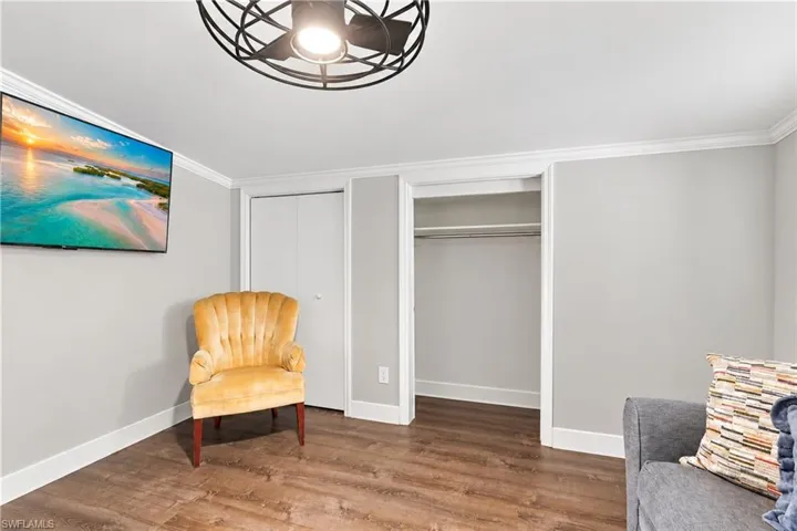 Wood-finish flooring, crown molding, and a built-in closet with shelving