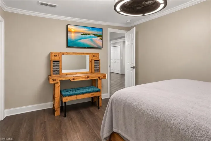 Neutral wall color, crown molding, and wood-finish flooring
