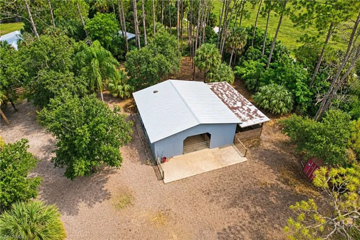 Barn structure with a metal roof, light blue siding, and concrete apron