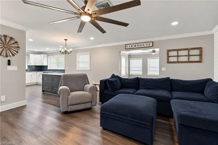 Wood-finish flooring throughout, recessed lighting, crown molding, open space living room connected to dining room and just outside gourmet master kitchen