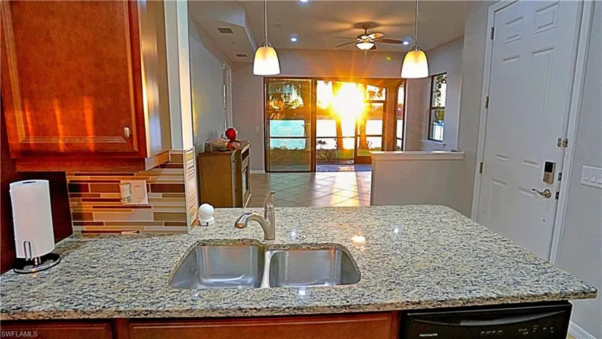 Kitchen with dishwasher, sink, ceiling fan, decorative backsplash, and decorative light fixtures