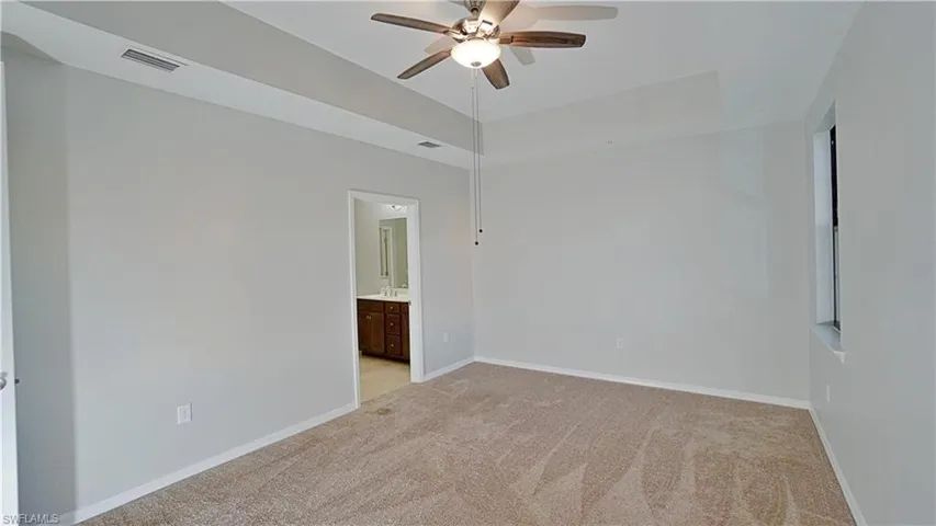 Unfurnished room with light colored carpet and ceiling fan