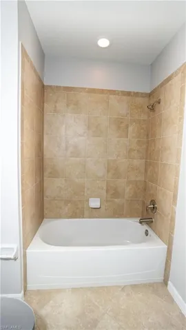 Bathroom featuring tile patterned floors and tiled shower / bath combo