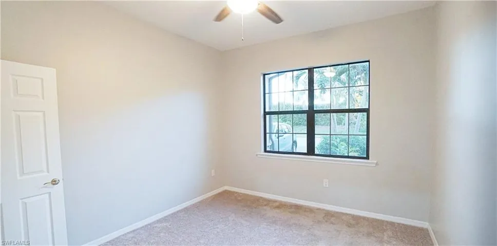 Carpeted spare room with ceiling fan