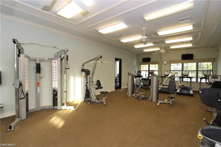 Workout area with ceiling fan and ornamental molding