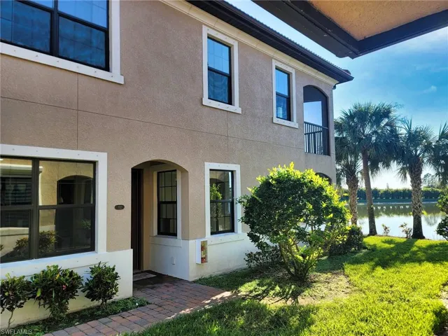 View of side of property featuring a balcony and a yard