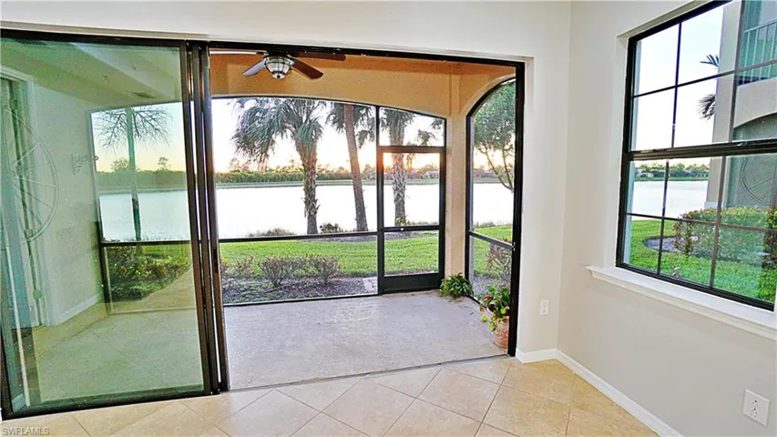 Entryway featuring light tile patterned floors, a water view, plenty of natural light, and ceiling fan