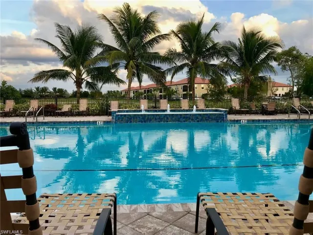 Pool at dusk featuring pool water feature
