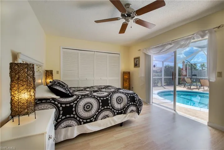Bedroom with light wood finished floors, access to exterior, ceiling fan, a closet, and a textured ceiling