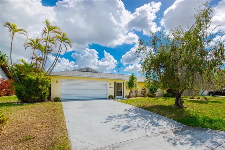 Single story home with a garage, concrete driveway, a front yard, and stucco siding